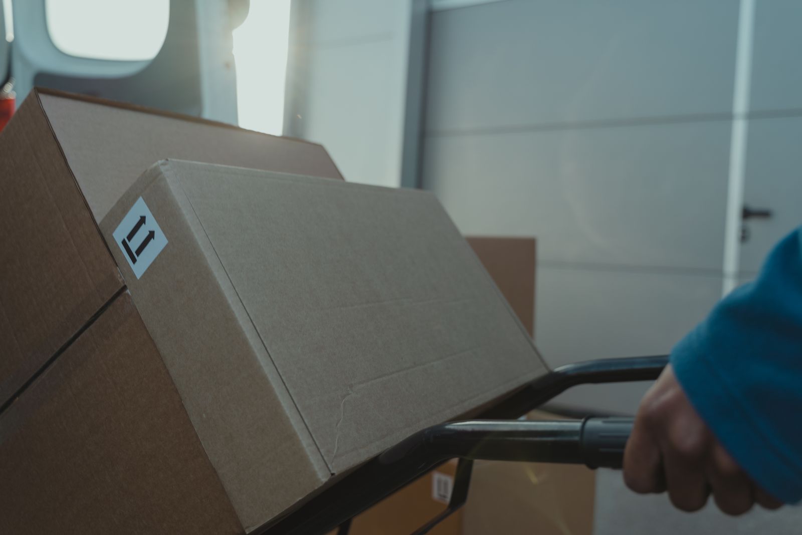 pexels-fulfillment-trolley Boxes stacked on a hand truck in warm light, representing quality control and fulfillment